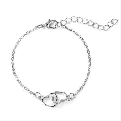 Silverpläterat armband med två sammanlänkade hjärtan. Modern och stilren, perfekt för romantiska tillfällen.